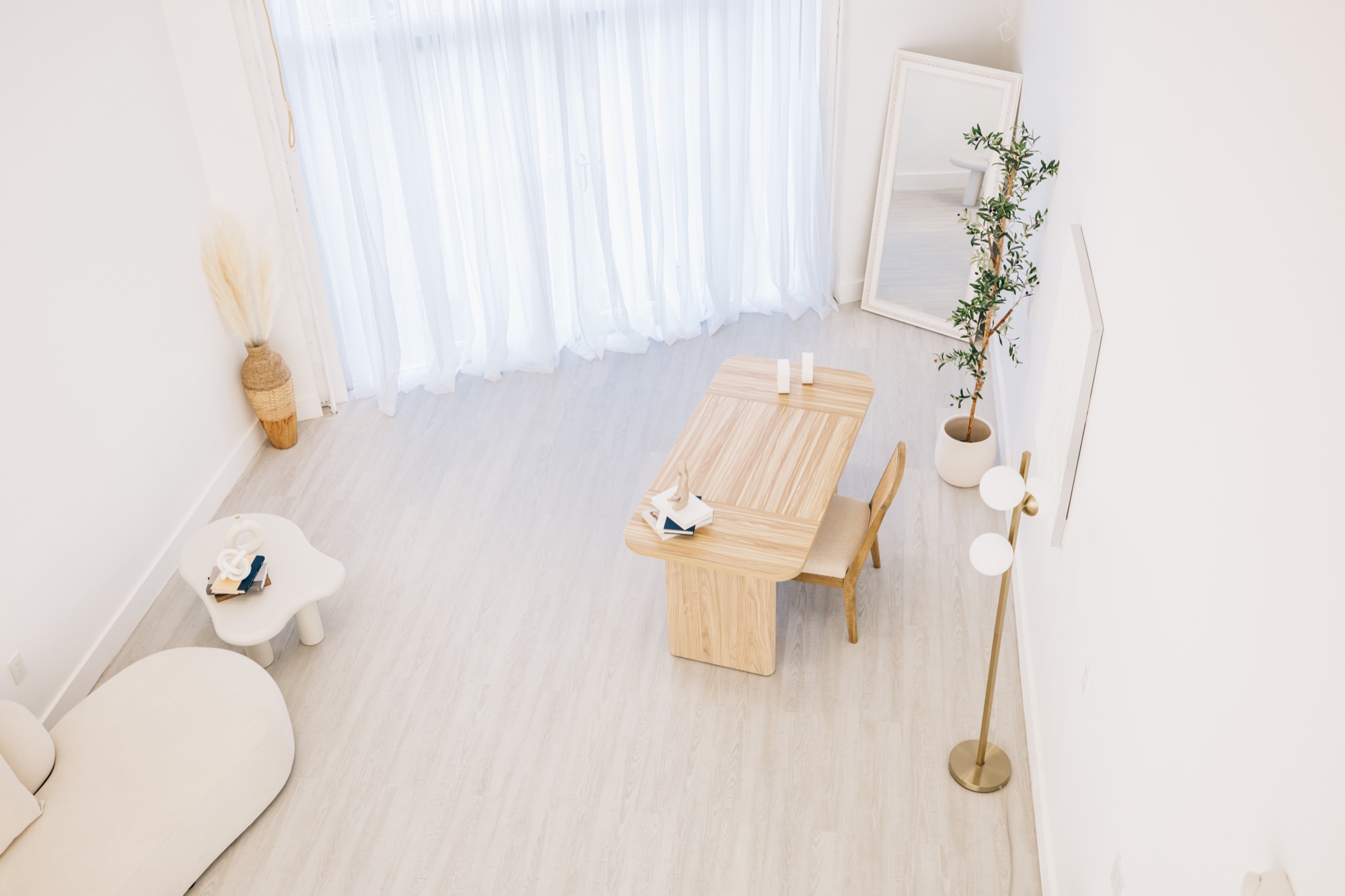 Natural light pouring across the studio floor through sheer white curtains