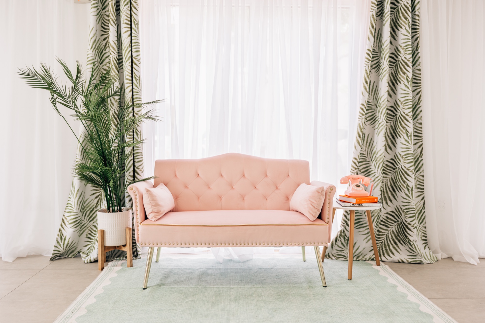 The Palm Springs–inspired pink set with a loveseat and palm-leaf drape