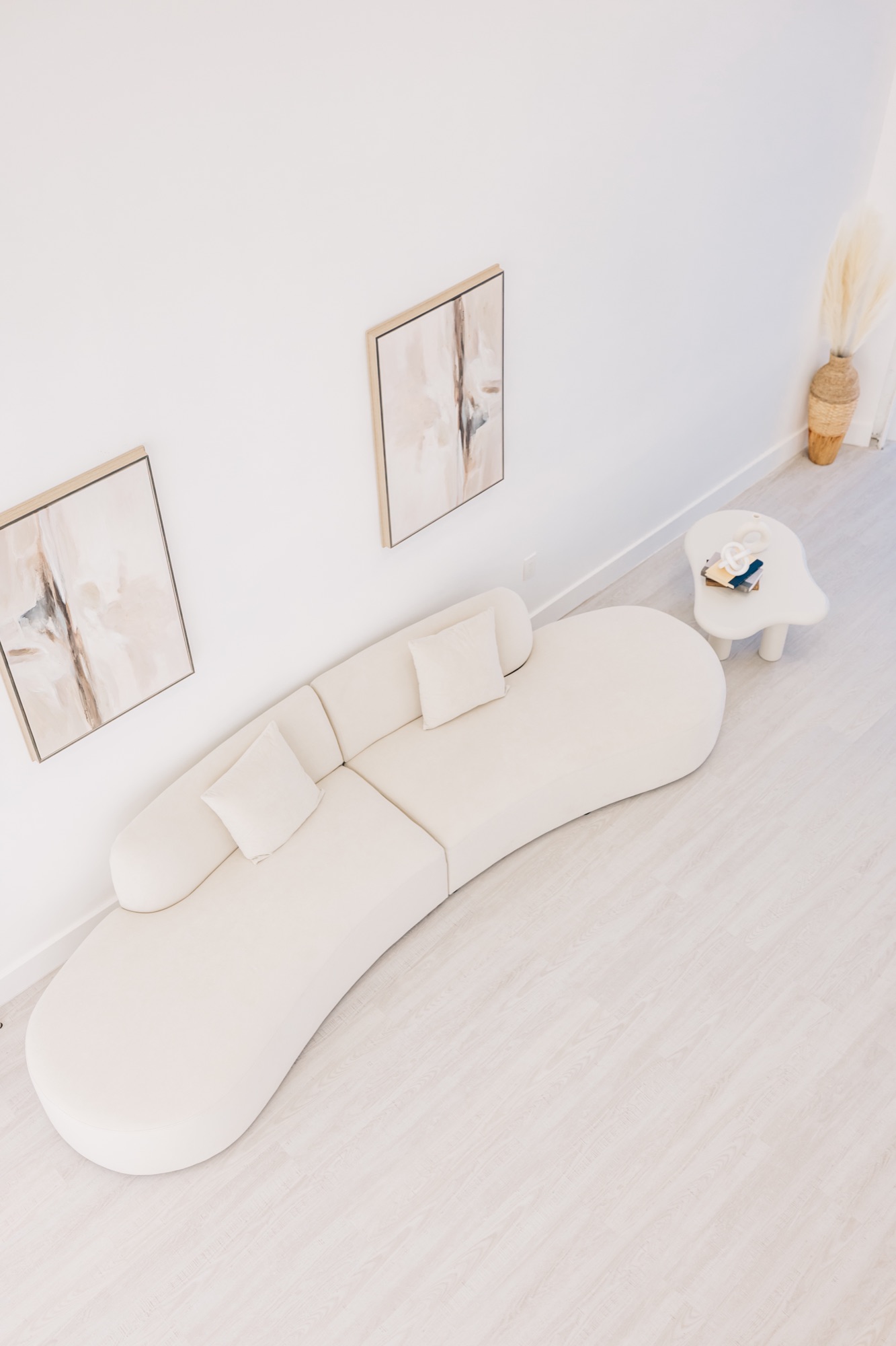 Wide overhead angle on the cream sofa and framed wall art