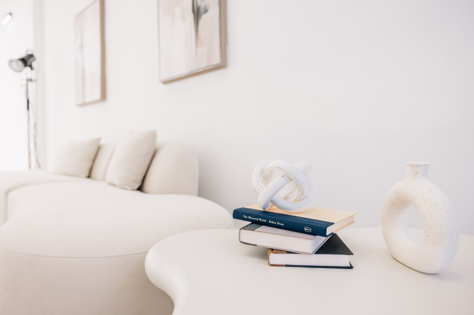 Softly lit sofa corner with a round side table and a single vase